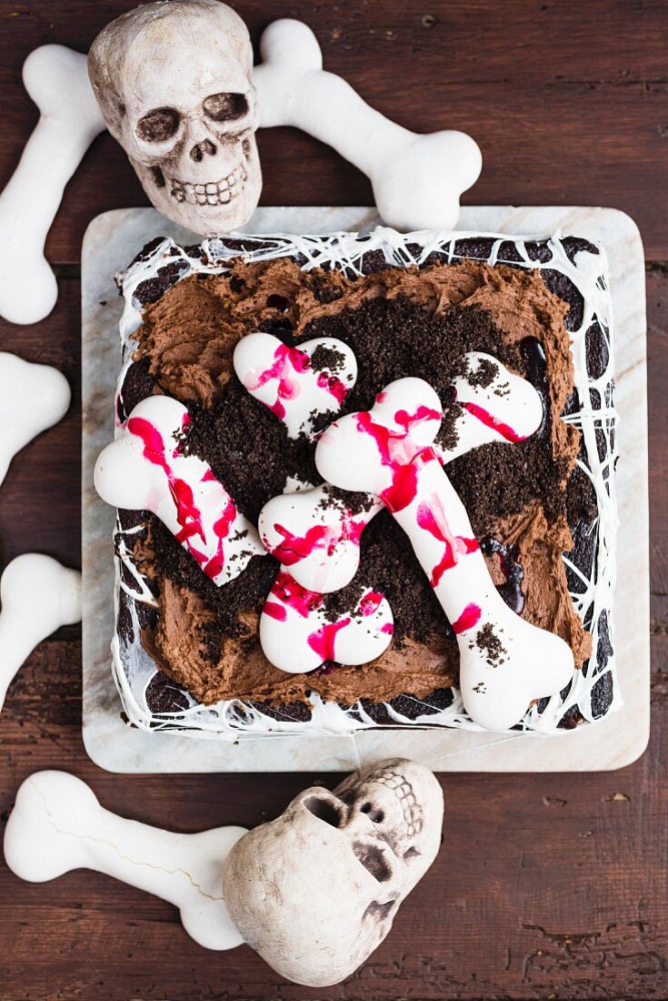 A Halloween graveyard cake with meringue bones and Oreo soil (seen from above)