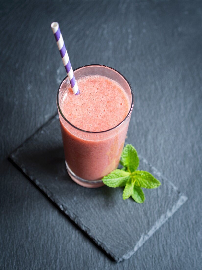 Milchfreier veganer roter Frucht-Smoothie im Glas mit Strohhalm