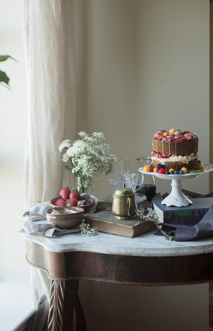 Vanillekuchen mit frischen Früchten auf Kuchenständer