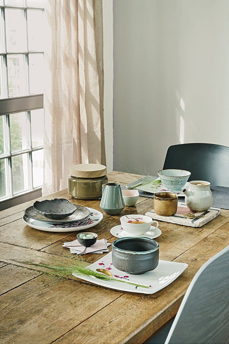 A tea table set in Asian style with ceramic and porcelain crockery