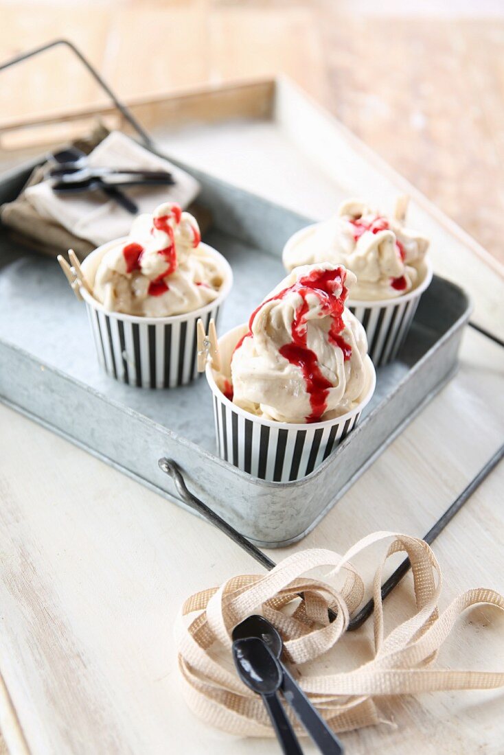 Raspberry ripple ice cream in paper cups on a metal tray