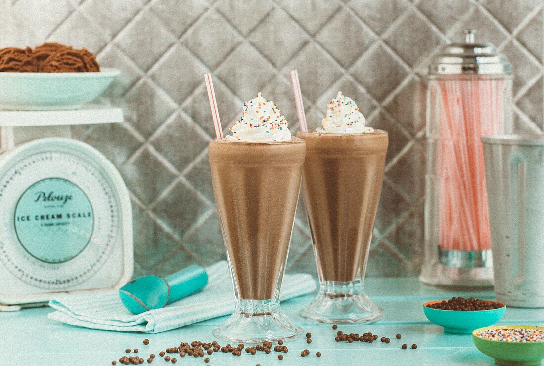 Two chocolate milkshakes in a vintage setting