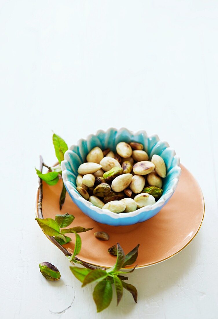 Roasted almonds and pistachios in a small bowl