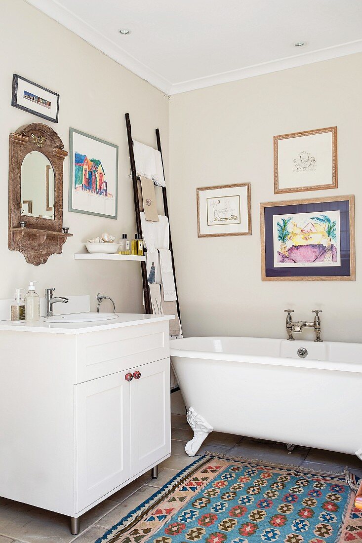 Free-standing bathtub and ladder used as towel rack in bathroom