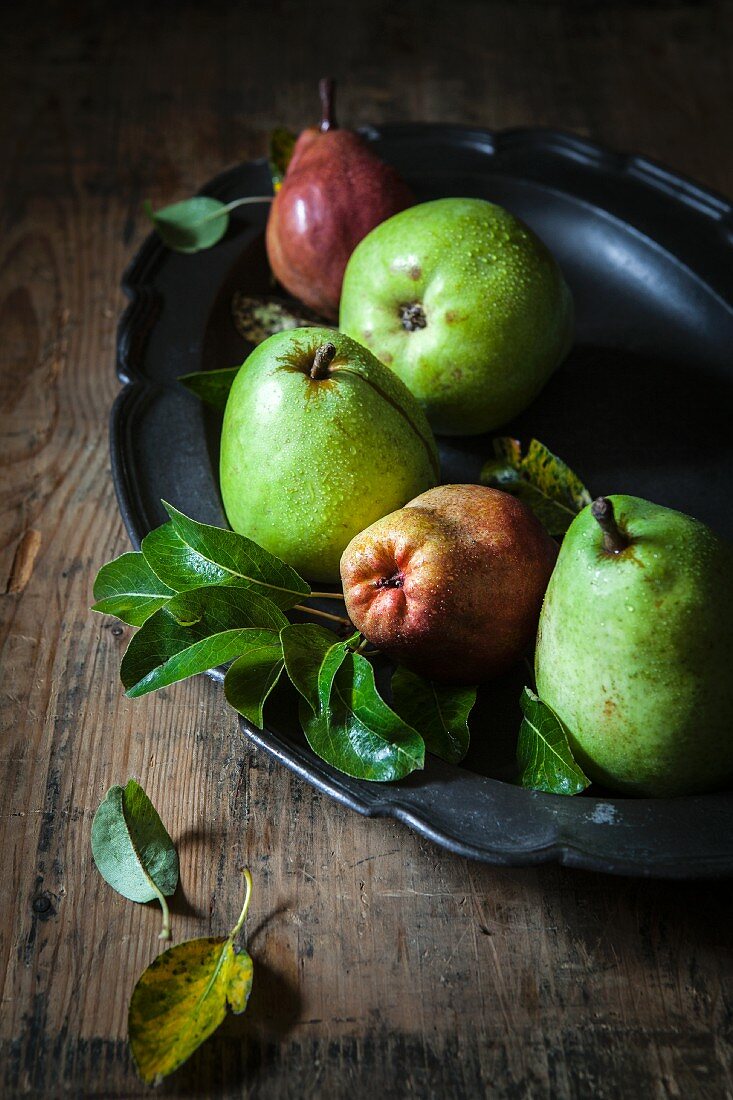 Red and green pears in a dish