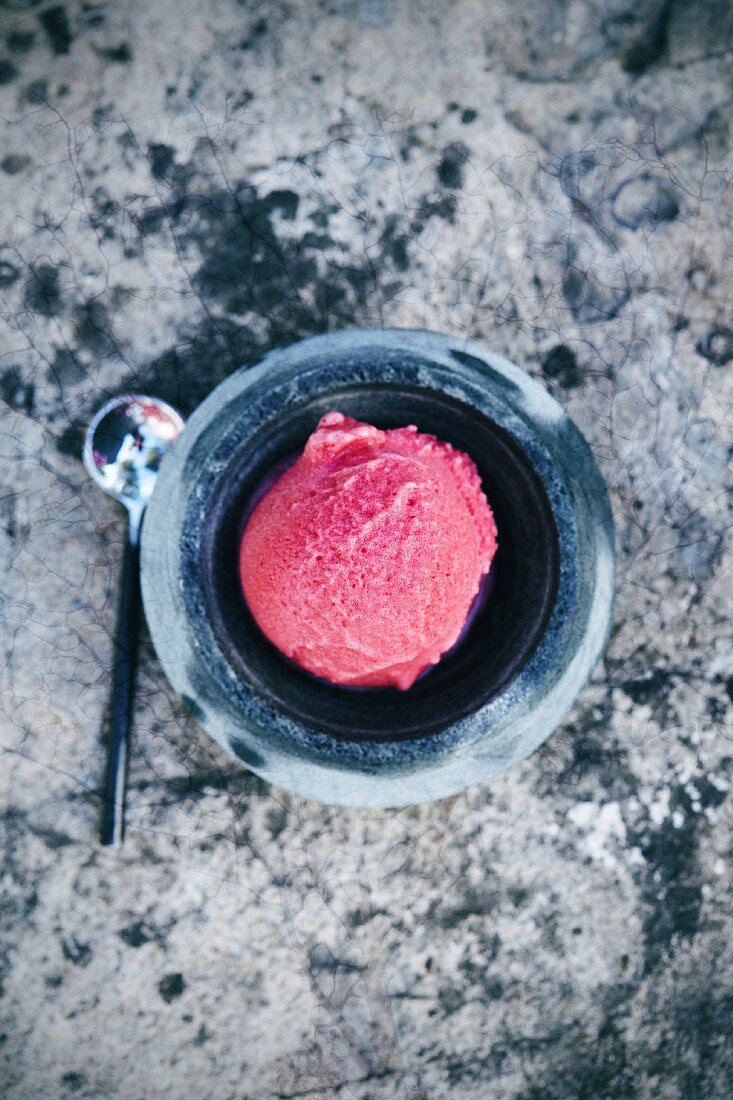 A scoop of raspberry ice cream in a bowl