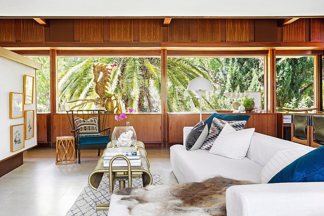 Lounge with wood paneling and palm tree views