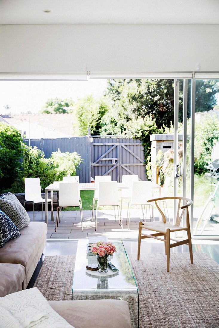 Living room with window front to the summer garden with dining table