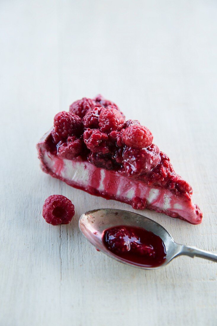A slice of vegan cheesecake with raspberries
