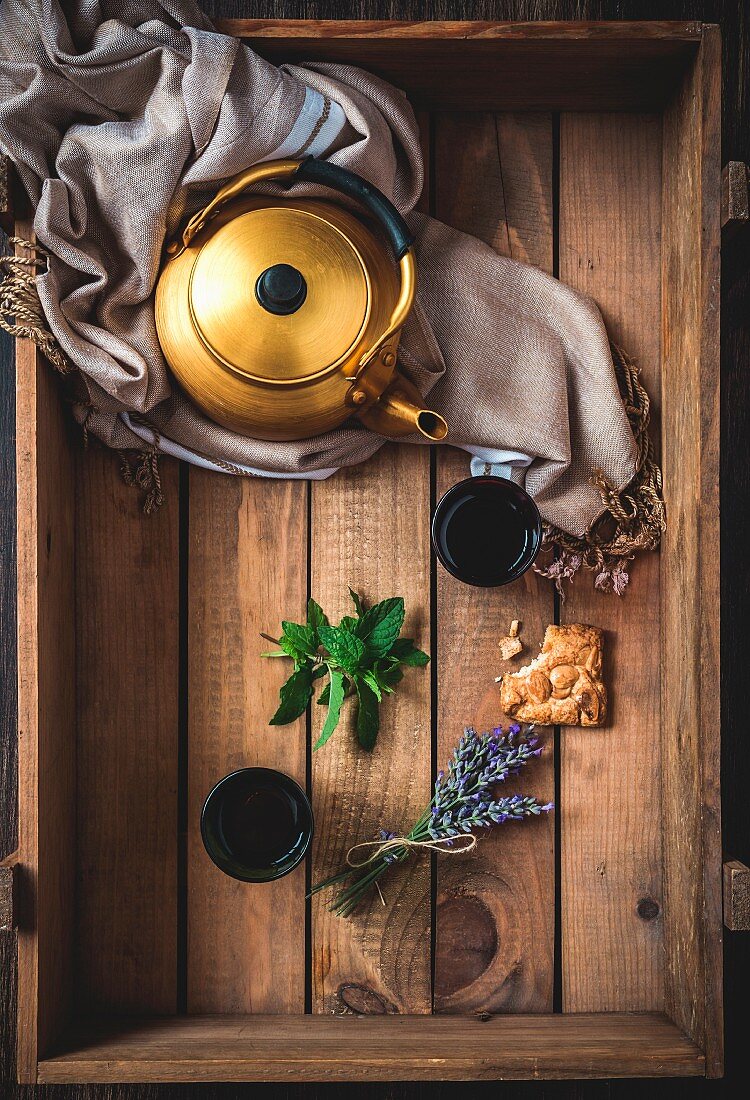 Arabic Nana mint tea in a teapot and glasses on a wooden tray