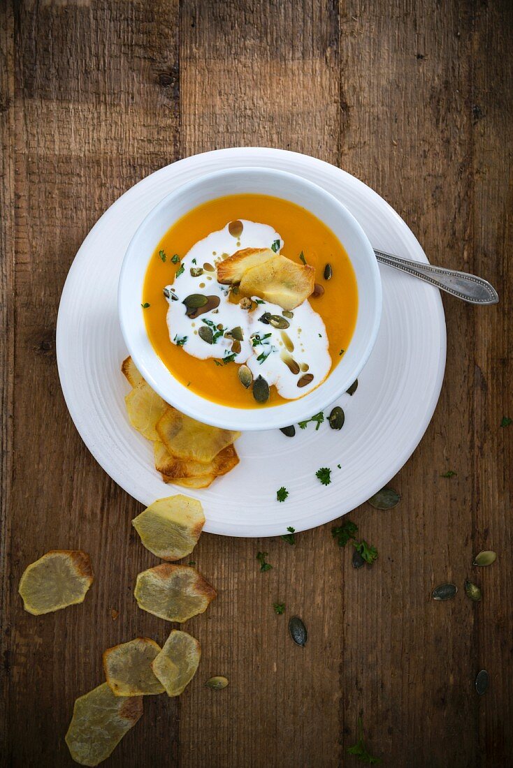 Vegan pumpkin soup with soya cream and potato chips