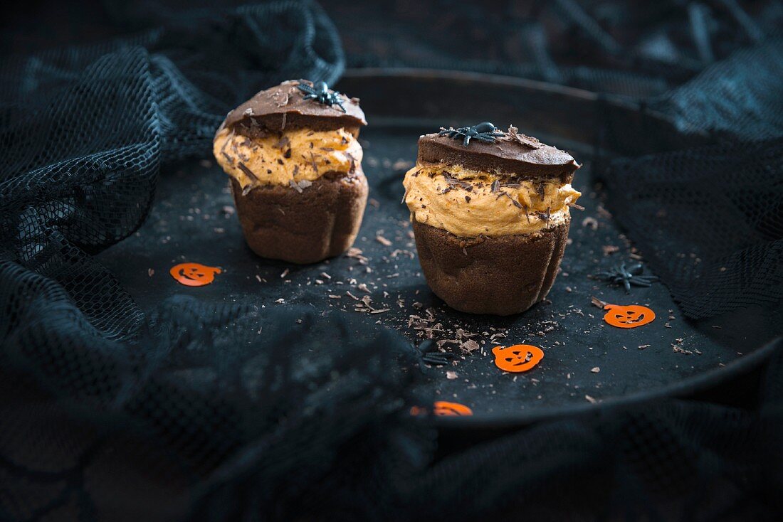 Vegan chocolate and pumpkin cupcakes with orange cream filling for Halloween