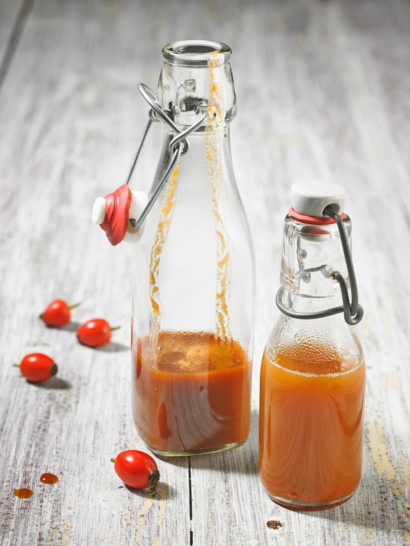 Rose hip juice in two partially filled clip top bottles