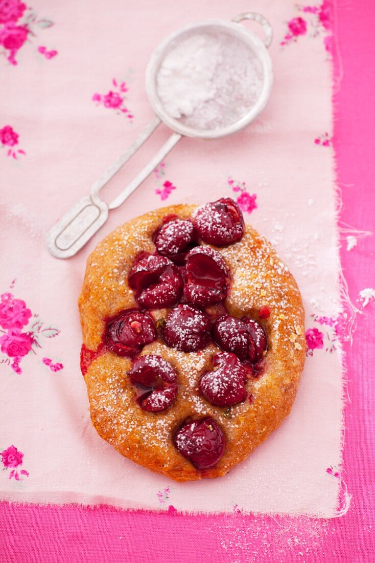 Sweet pastry with cherries and icing sugar