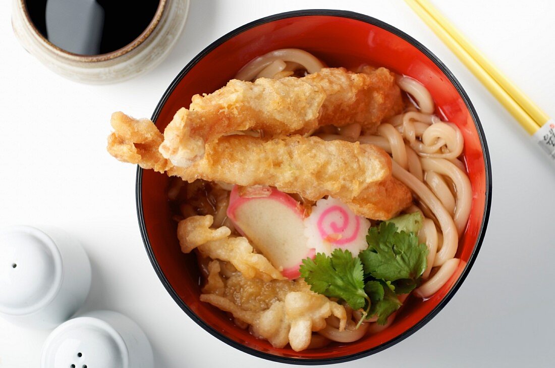 A broth with wheat noodles, vegetables and prawn tempura (Asia)