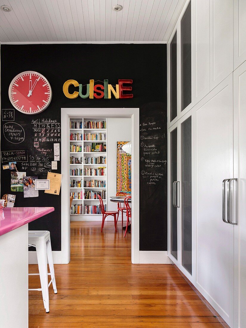 Black chalkboard paint on kitchen wall with passage into dining area