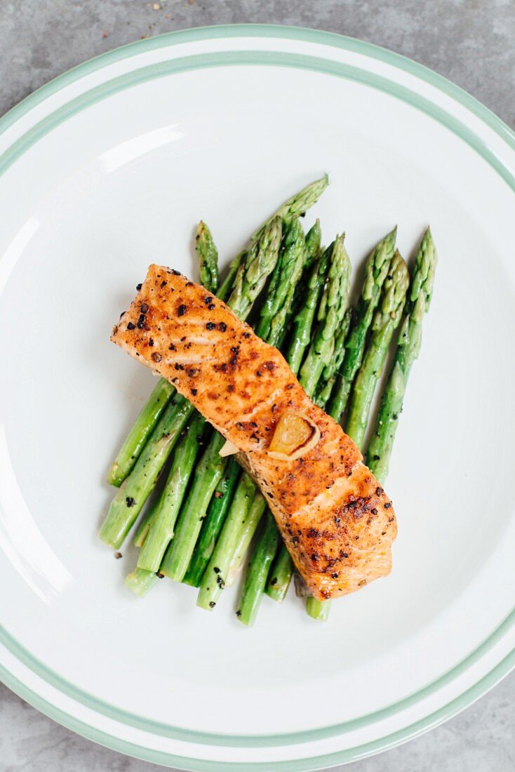 Grilled salmon fillet on a bed of green asparagus