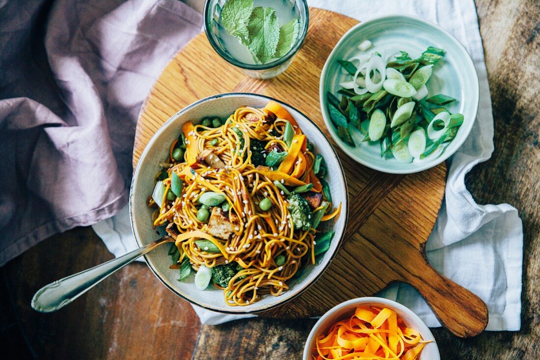 Noodles with carrots, peas, leek and sesame seeds