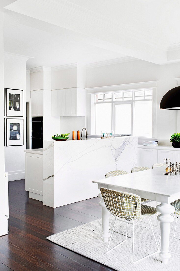 Bright, open kitchen and dining room with white furniture