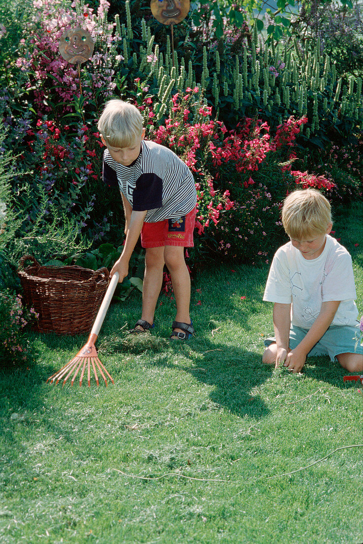 Children rake grass clipping together