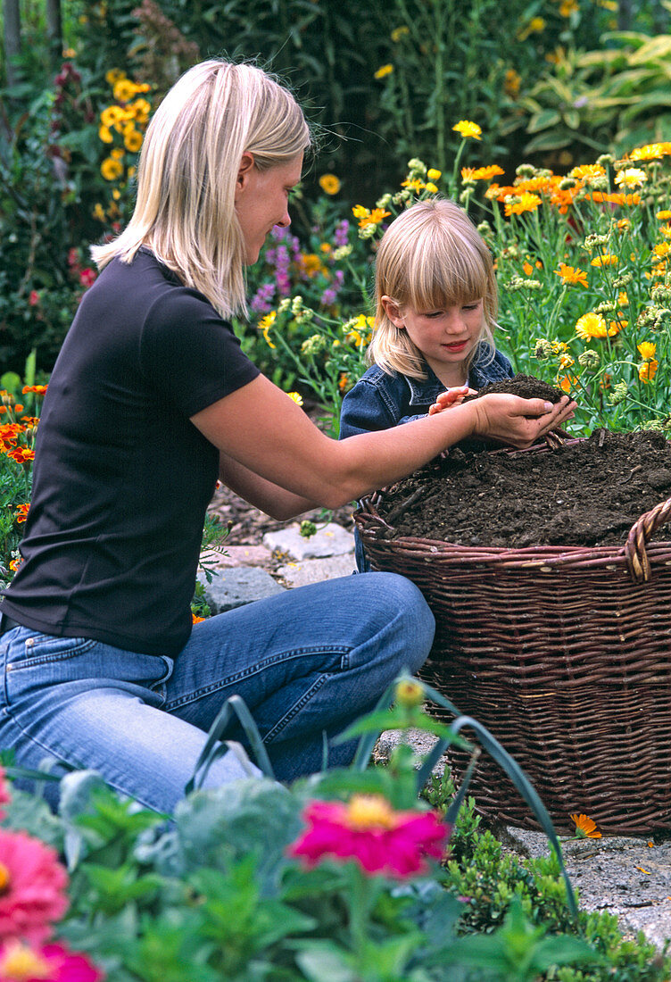 Young woman checking compost (or earth)