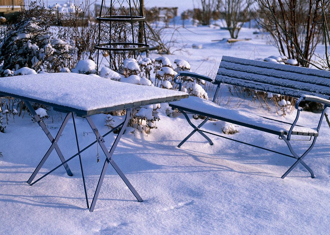 Snowy garden with bench and table