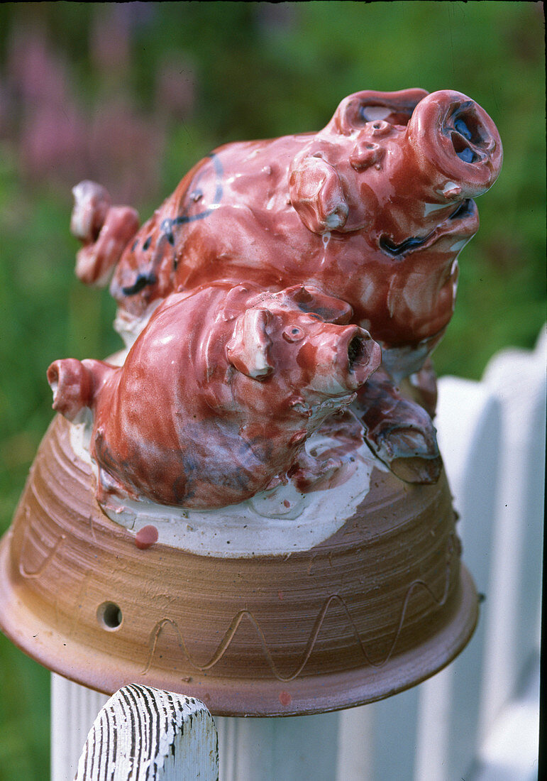 Ceramic pigs filled with wood wool as earwig houses