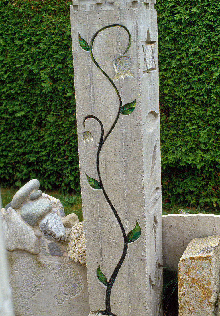 Betonsäule als Skulptur mit Blumenranke