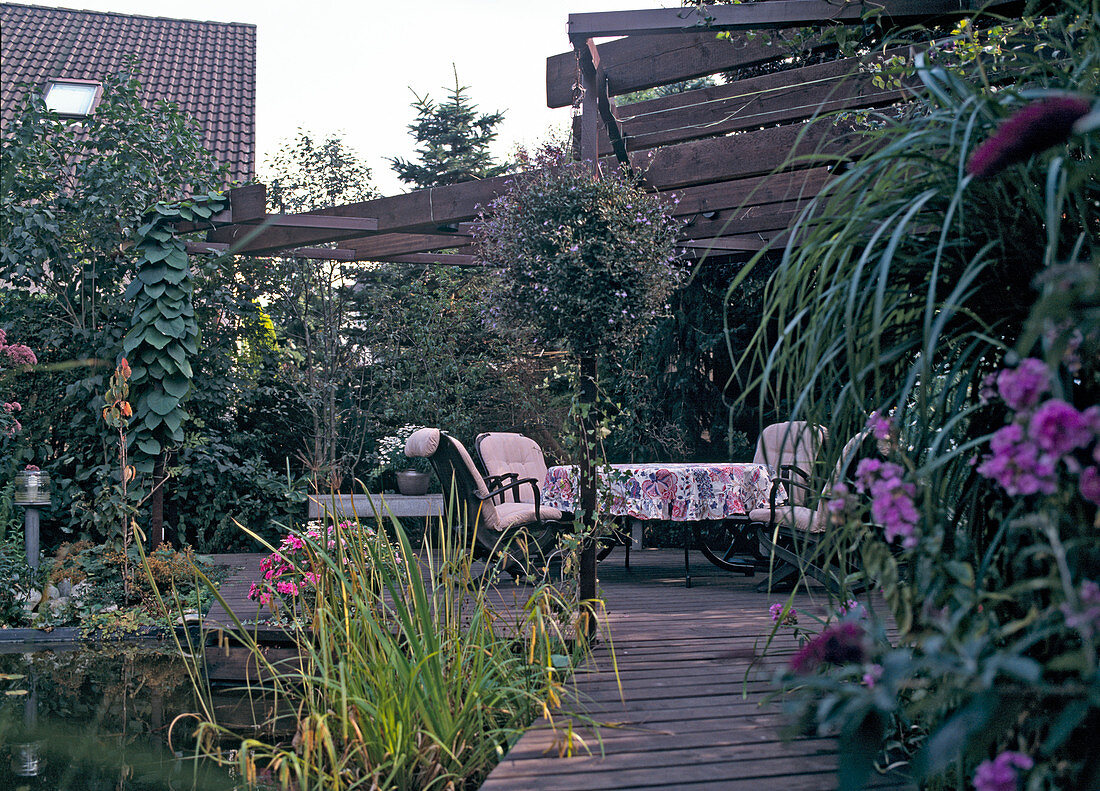 Wooden terrace with pergola by a pond