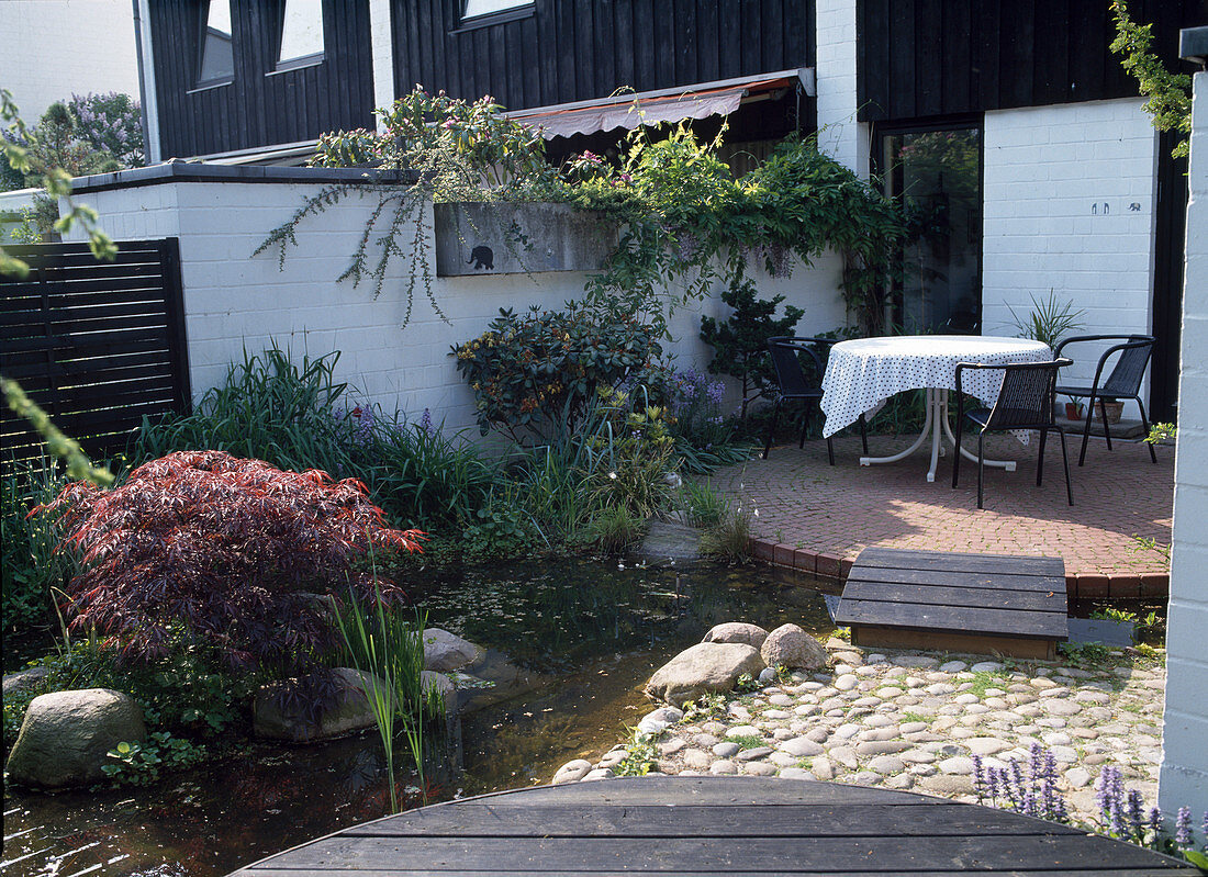 Terrace with pond and wooden footbridge in one