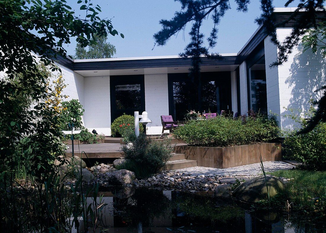 General view of the small garden with wooden terrace and pond