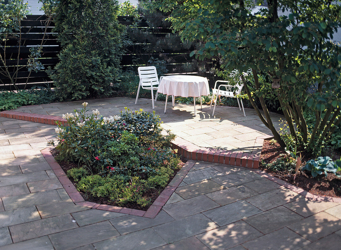 Seating area by the house with flower bed