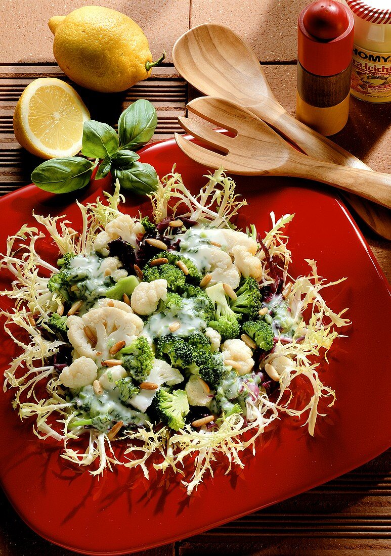 Broccoli & cauliflower salad with pine nuts on curly endive