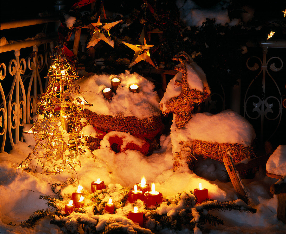 Christmas atmosphere with candles and fairy lights outside in the snow