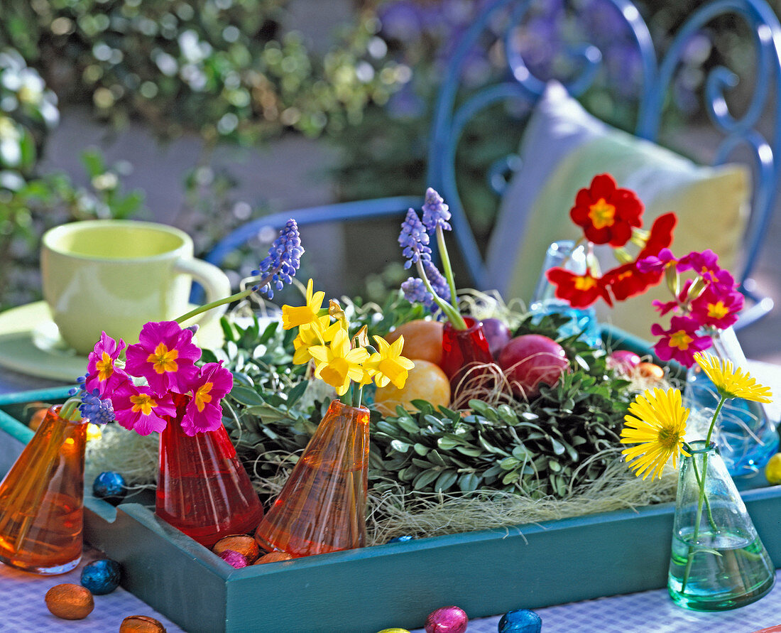 Tray with a buxus wreath, boiled eggs, vases with flowers