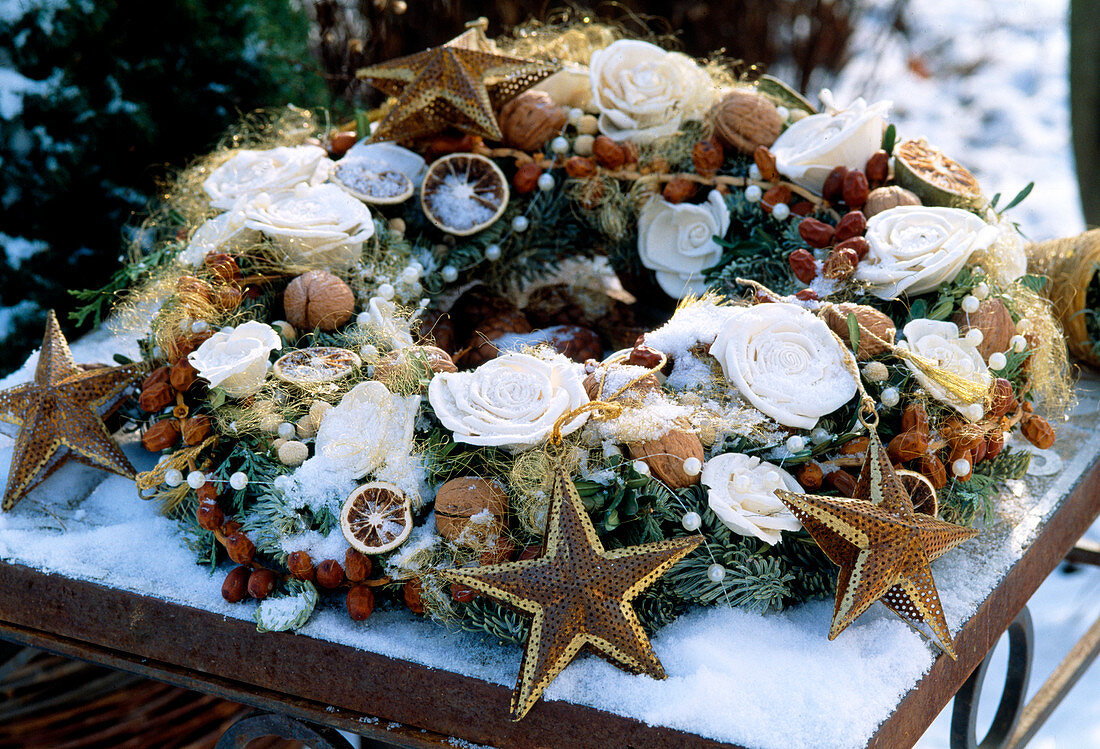 Weihnachtlicher Kranz mit Dekorosen, Nüssen, Sternen und Perlenkette