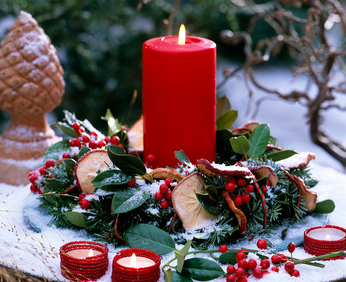 Kranz aus Abies (Nordmanntanne), Ilex (Stechpalme), Malus (Apfelscheiben), rote Kerze