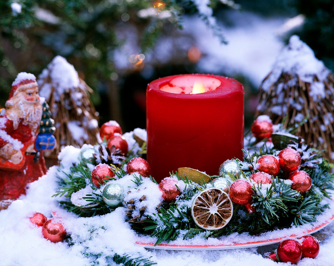 Plate wreath with Nordmann fir, lime slices, red Christmas baubles, red candle