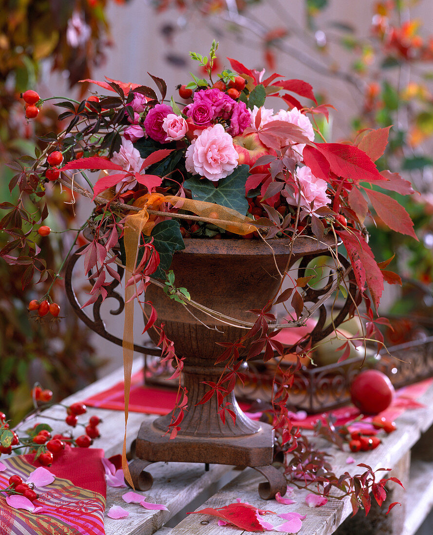 Iron spindle with pink (roses) and rose hips, Parthenocissus (wild vine)