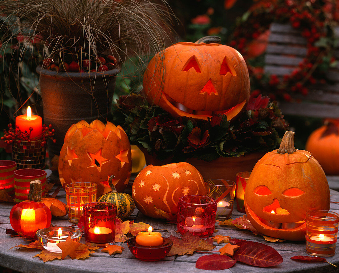 Table with hollowed out carved pumpkins with faces and stars, candle