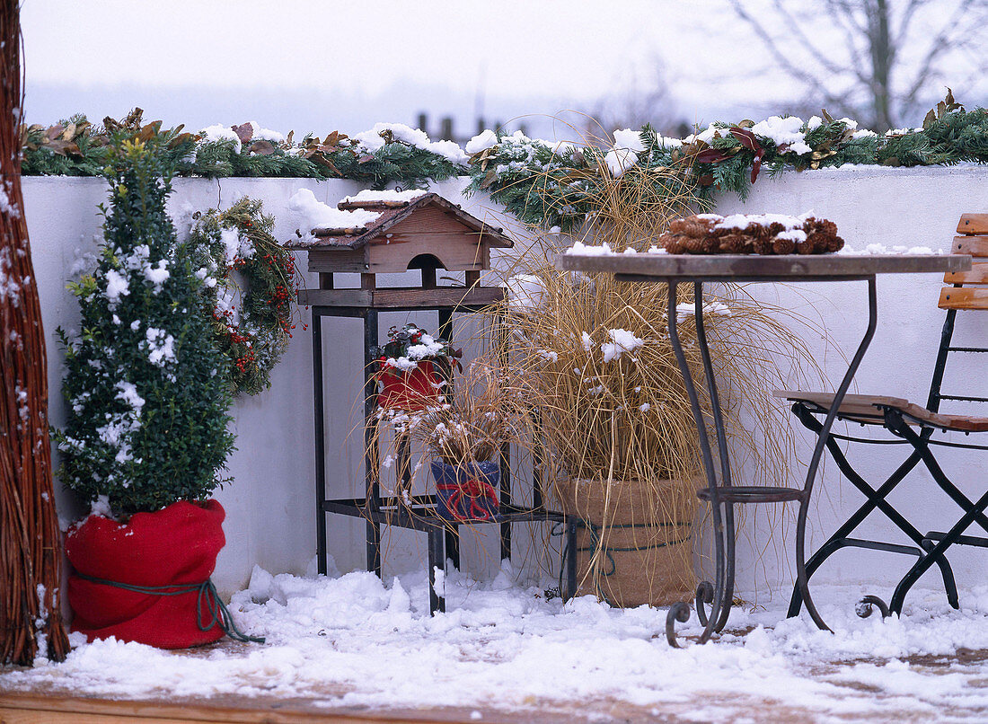 Winterbalkon mit Vogelhaus, Gräser mit Ballenschutz, Picea (Zapfenkranz), Girlande