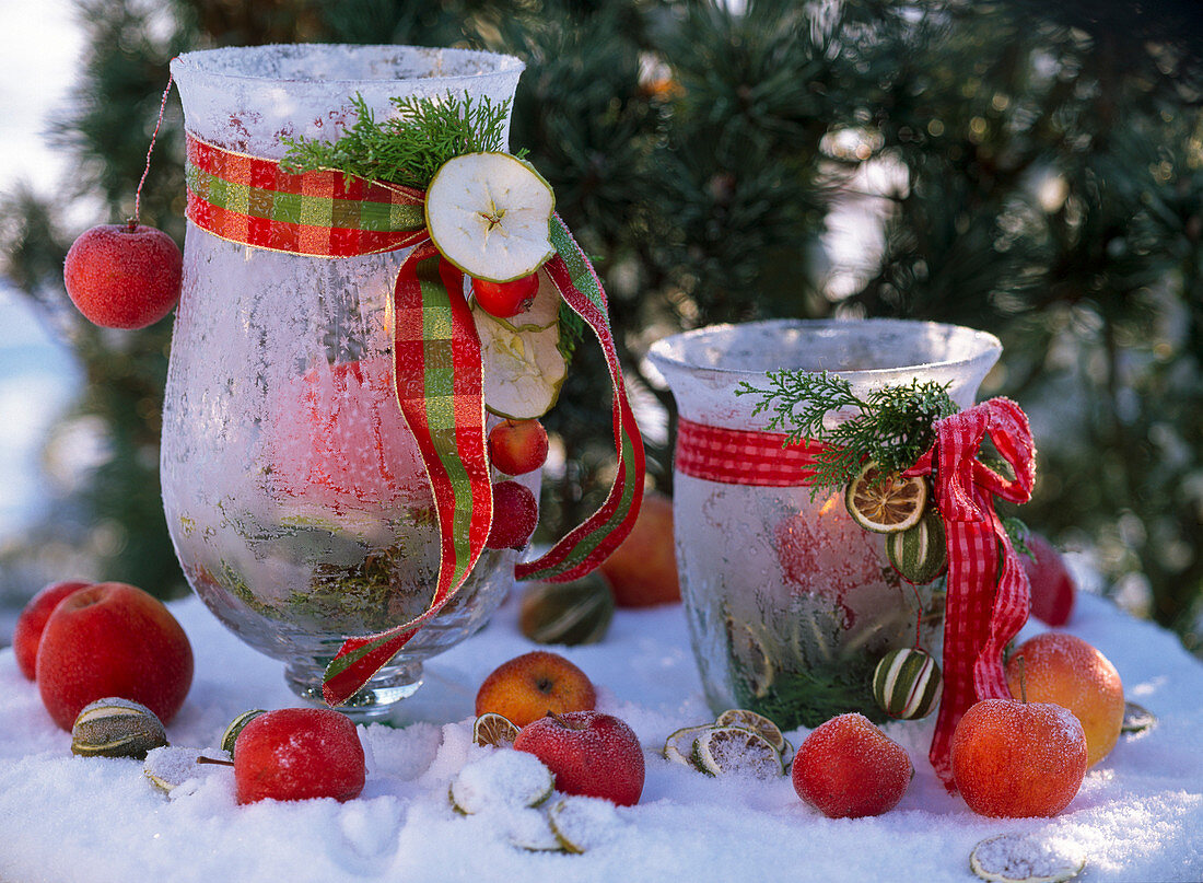 Lantern with hoarfrost, decorated with a bow, malus apples and twigs