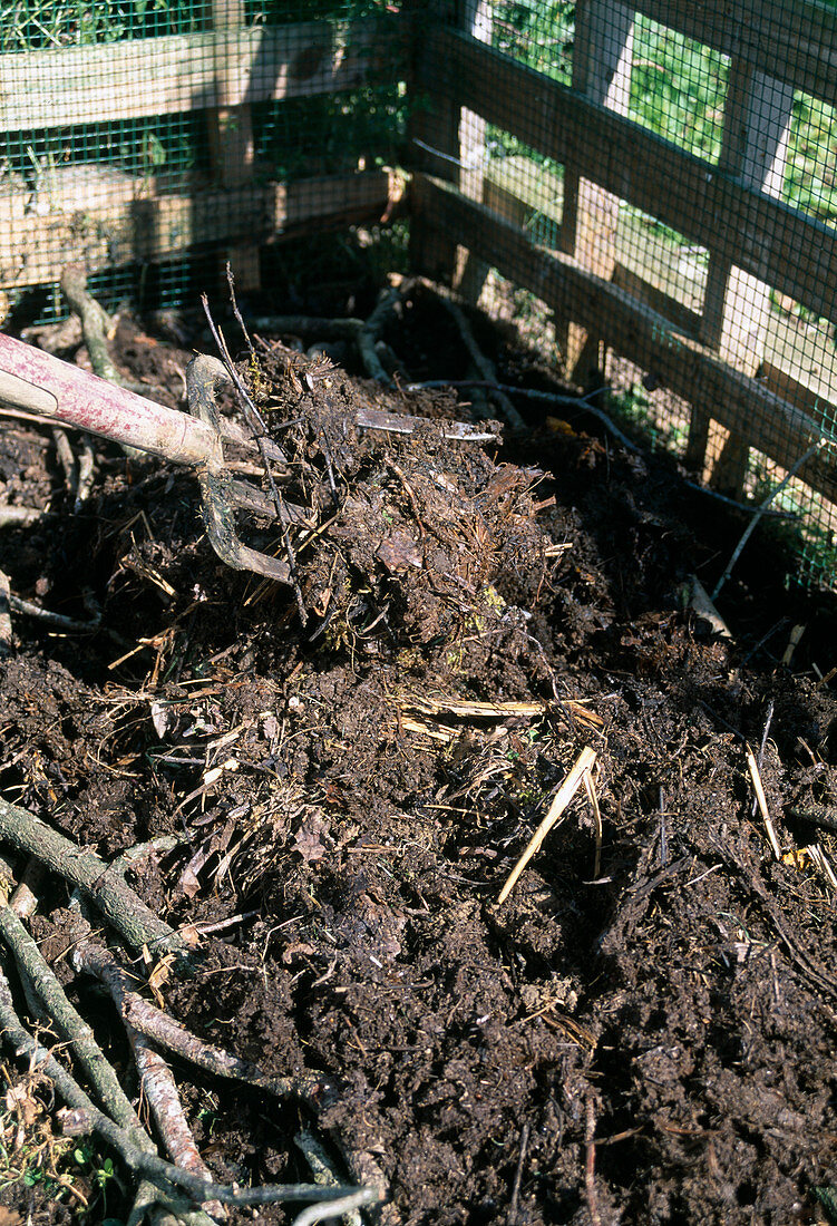 Building a compost - covering the first layer with old compost (2/8)