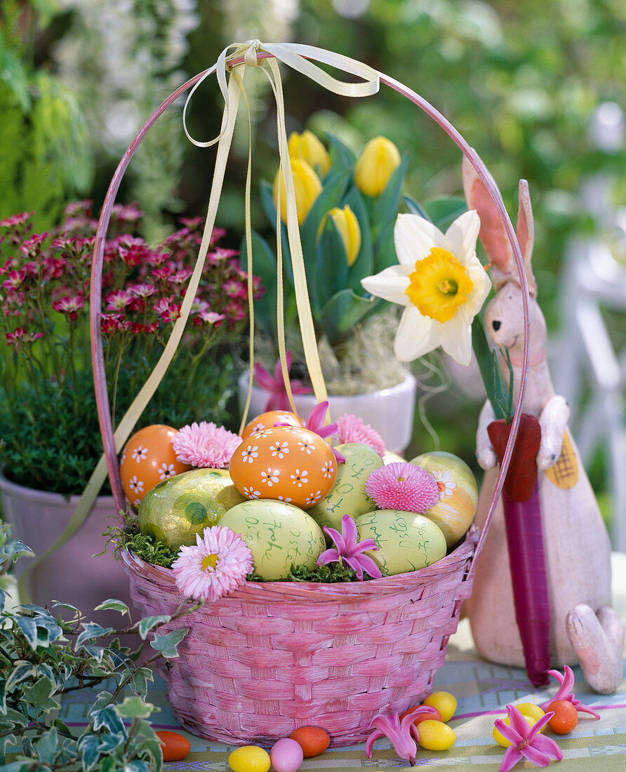 Pink basket with Easter eggs and flowers