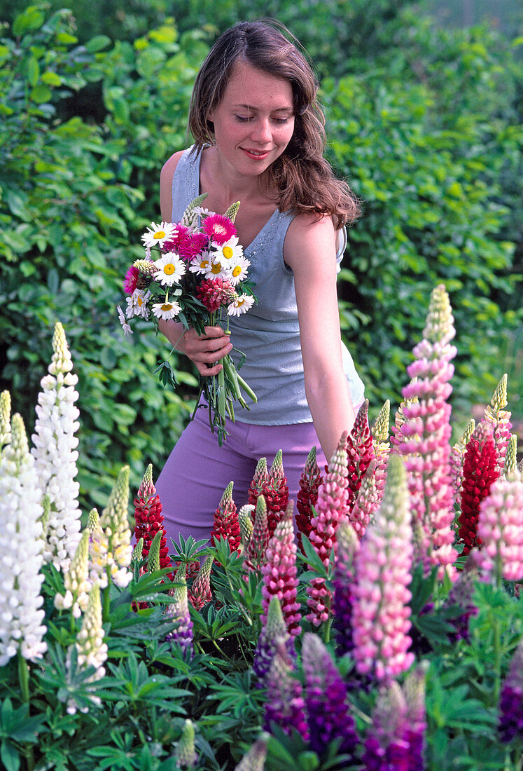 Young woman with floral bouqut snout Lupinus (lupine)