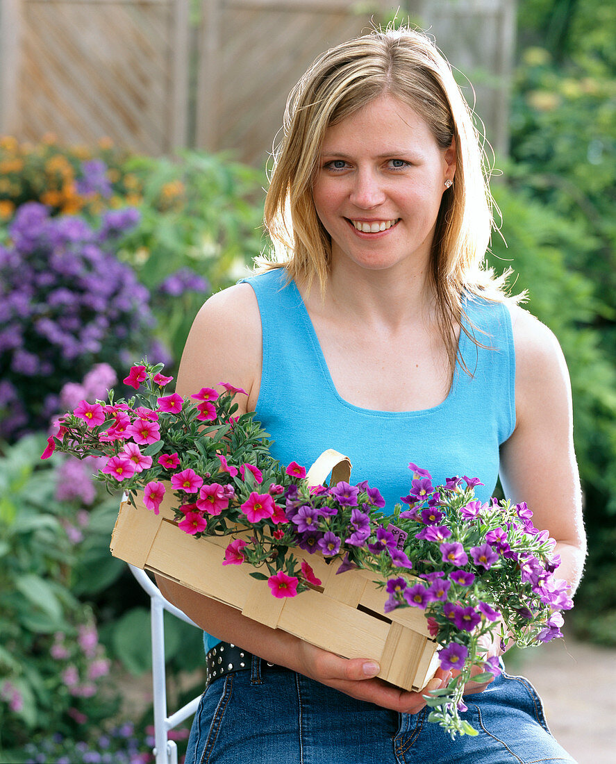 Young Woman with Calibrachoa Celebration 'Dark Blue' - 'Pink'