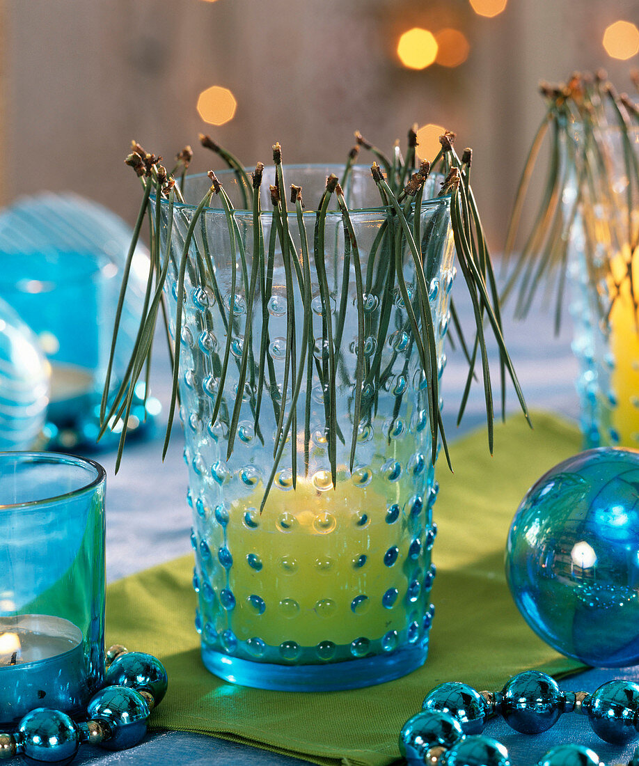 Blue glass as lantern decorated with Pinus (pine needles), globe wreath