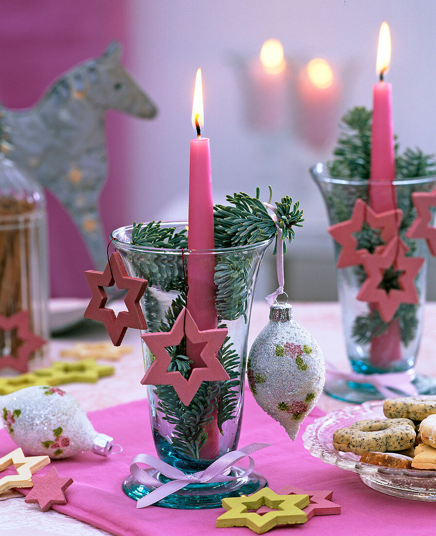 Windlicht mit rosa Kerze, Baumschmuck und Holzsternen