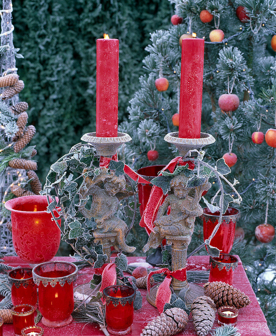 Rote Kerzen in Kerzenhaltern mit Engeln und Hedera (Efeu), rote Windlichter