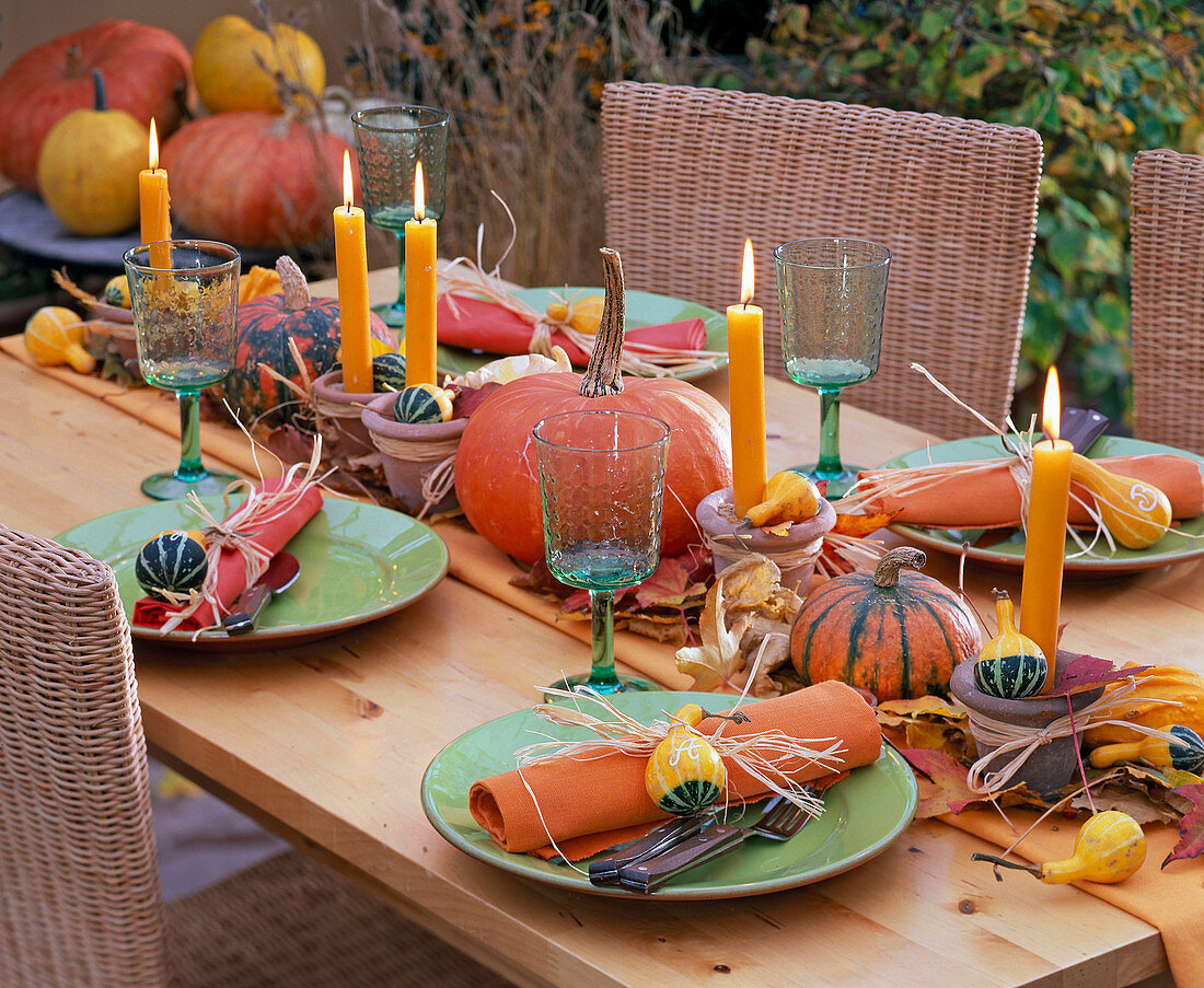 Herbstliche Tischdekoration mit Cucurbita (Kürbissen) in der Mitte des Tisches